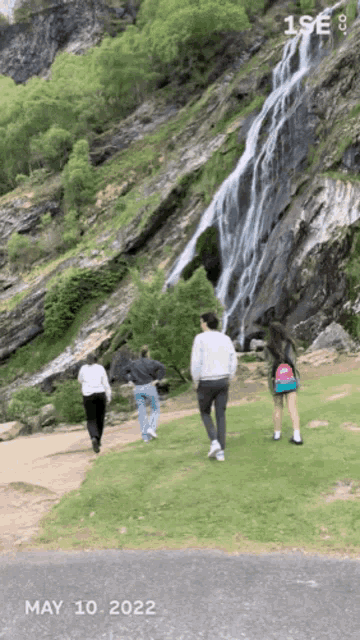 people walking near a waterfall on may 10th 2022