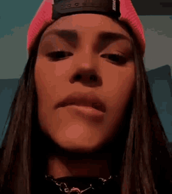 a close up of a woman 's face wearing a pink hat .