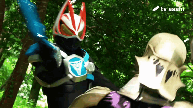 a man in a superhero costume is fighting another man with a tv asahi logo in the background