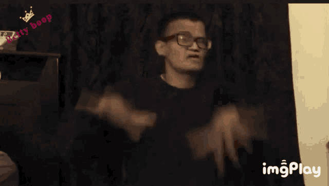 a man with glasses is making a funny face in front of a sign that says imgplay