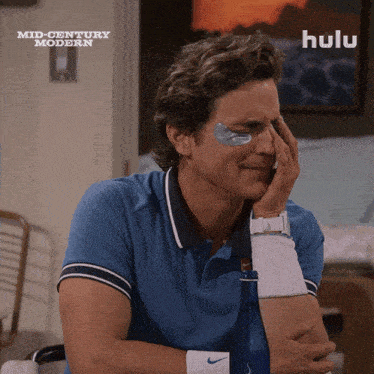 a man with eye patches on his face is sitting in front of a hulu logo