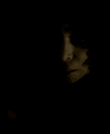 a close up of a person 's face in the dark .