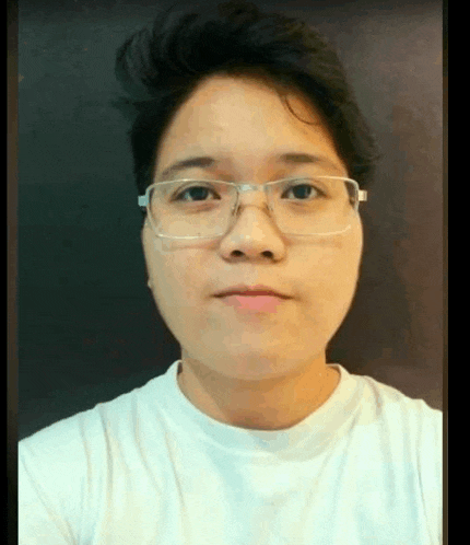 a woman wearing glasses and a white shirt is looking at the camera .