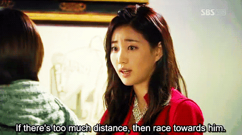 a woman in a red shirt is talking to another woman and says if there 's too much distance then race towards him