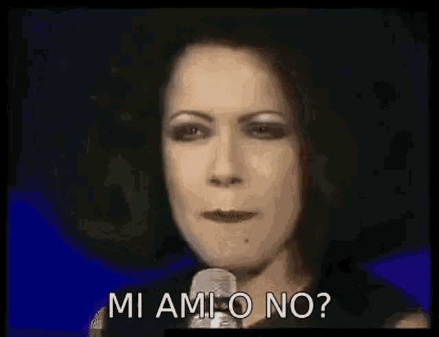 a woman is standing in front of a microphone and saying `` mi ami o no '' .