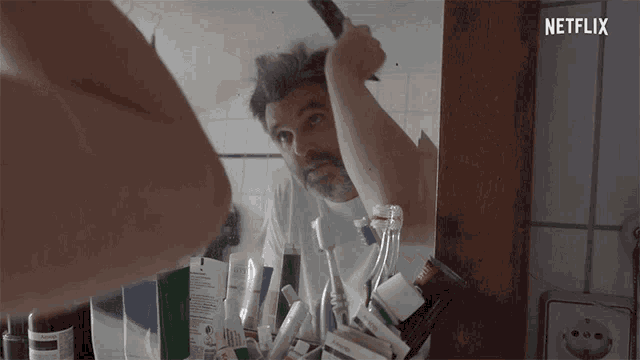 a man brushing his hair in front of a mirror with netflix written on the bottom right