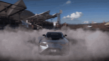 a car is drifting on a track with smoke coming out of the tire