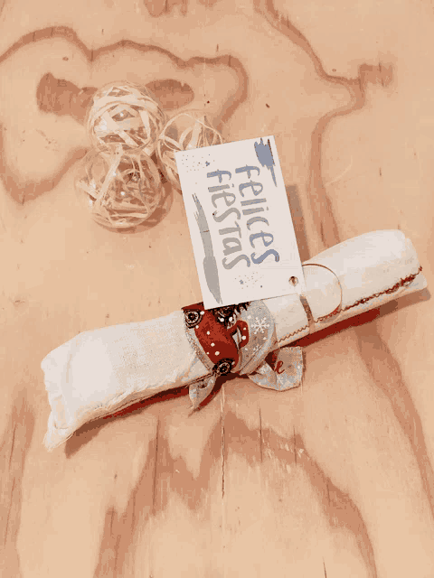 a piece of paper with a tag that says felices fiestas on it