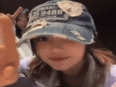 a woman wearing a denim hat that says j9488 on it