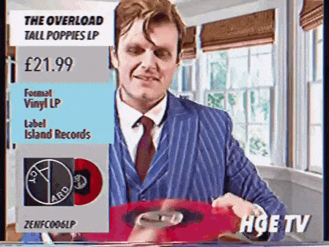 a man in a suit and tie is holding a red record labeled island records ..