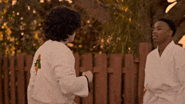 two young men in white karate uniforms are standing next to each other