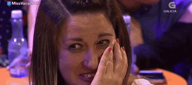 a woman covering her face with her hand while watching a tv show called miss vaca 2018
