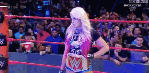 a woman is standing in a wrestling ring wearing a t-shirt that says ' miss ' on it .