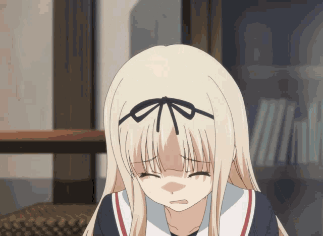 a girl with blonde hair and a bow on her head is crying