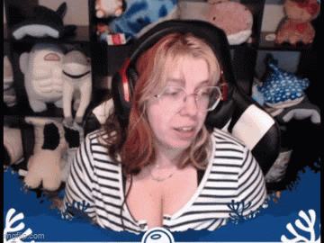 a woman wearing headphones and a striped shirt is sitting in front of stuffed animals ..