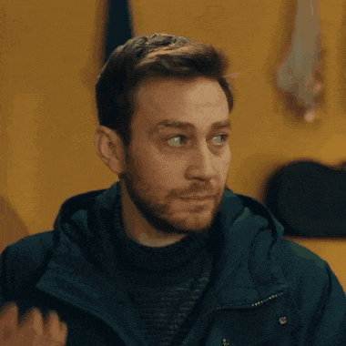 a man with a beard wearing a blue jacket and a black sweater