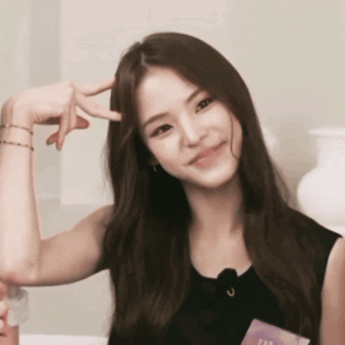 a woman in a black tank top is making a funny face