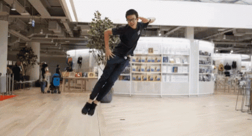 a man is jumping in the air in front of a store