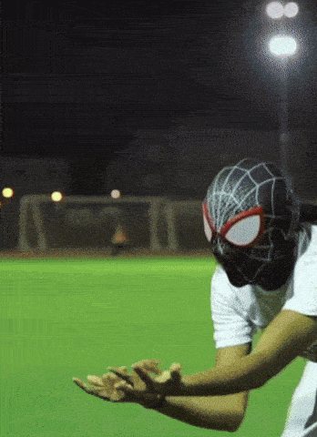 a person wearing a spider-man mask on a soccer field
