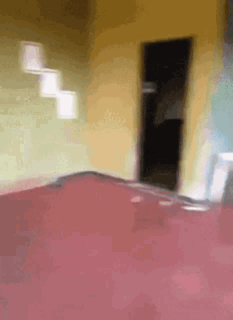 a blurry picture of a room with a red bed