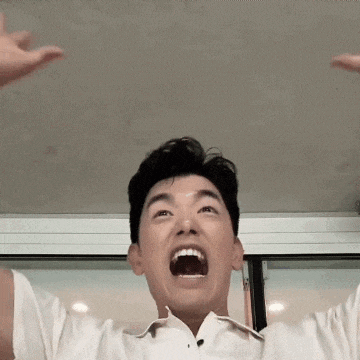 a man in a white shirt is making a funny face with his mouth wide open .