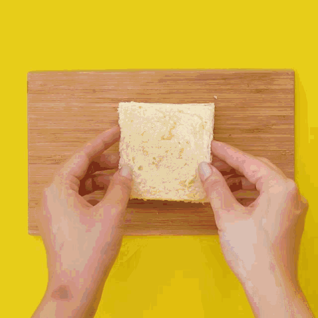 a person is using a fork to cut a piece of bread