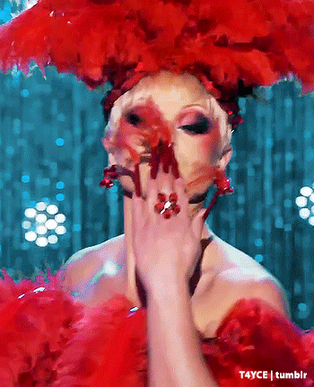 a woman in a red dress is covering her face with her hands