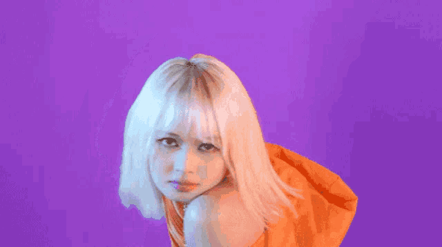 a woman with blonde hair is wearing an orange shirt