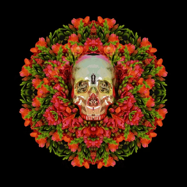 a silver skull is surrounded by pink flowers