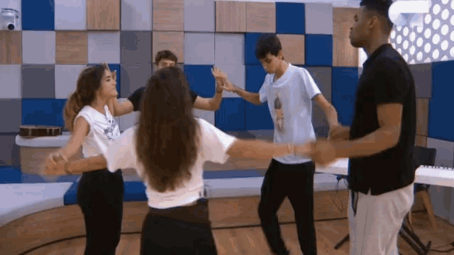 a group of people are dancing in a room with a piano