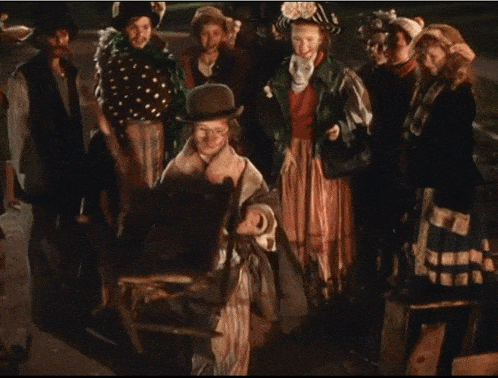 a group of people dressed in costumes including a man in a top hat