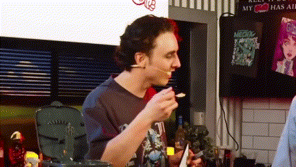 a man is eating ice cream with a spoon in a kitchen .