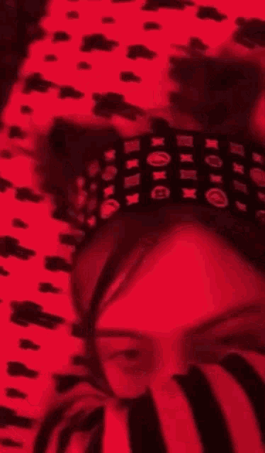 a woman wearing a headband with the letter o on it covering her mouth