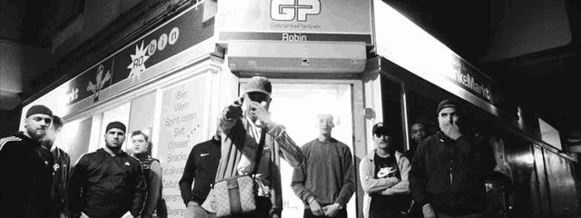 a group of men are standing in front of a store called gp