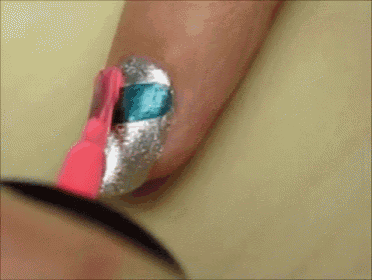 a close up of a person 's nails being painted with a pink brush
