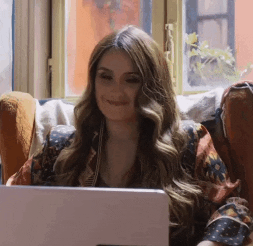 a woman is sitting in a chair with a laptop computer .