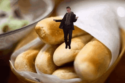 a man in a suit is standing in a basket of bread
