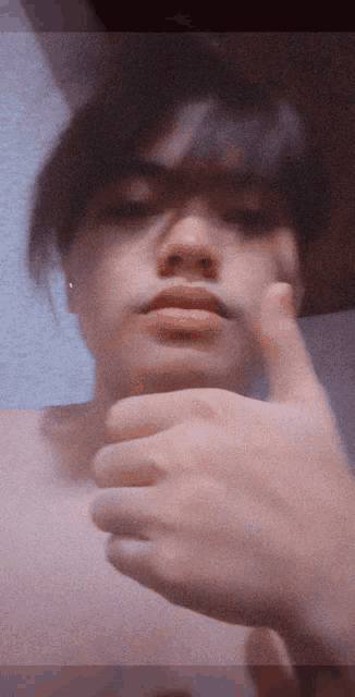 a shirtless person is giving a thumbs up
