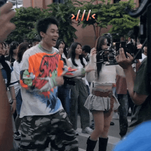 a man wearing a shirt that says ' shin ' on it stands in a crowd