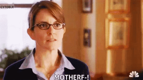 a woman wearing glasses and a blue shirt is making a funny face and saying motherf .