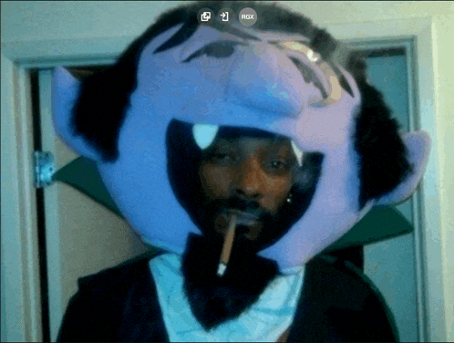 snoop dogg wearing a purple vampire hat smoking a cigarette