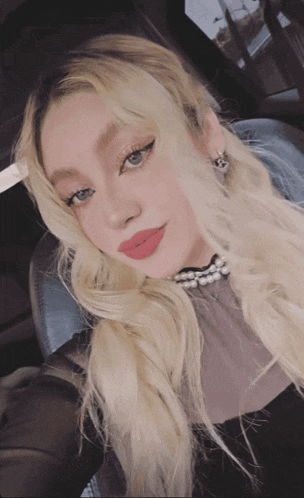 a woman with blonde hair is wearing red lipstick