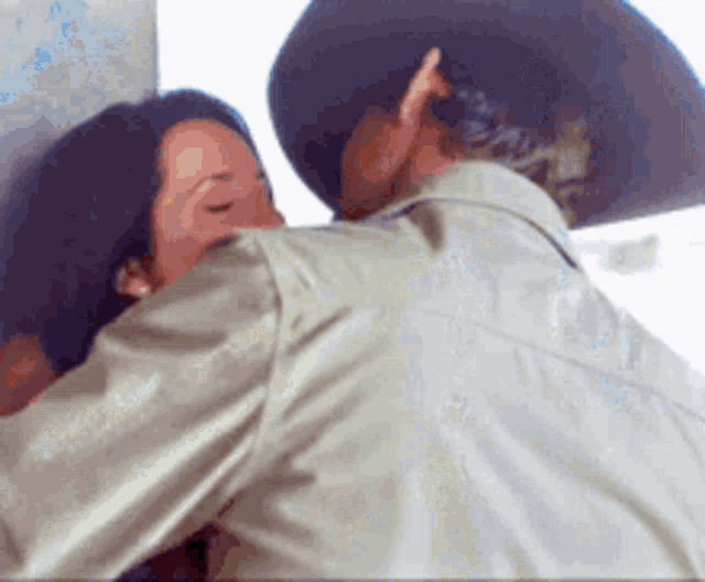 a man and a woman are kissing in a room