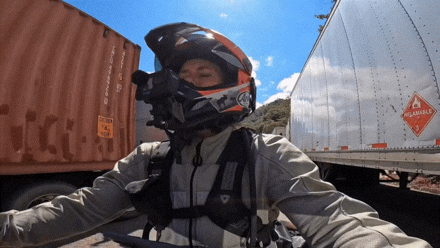 a person wearing a helmet is standing in front of a container that says flammable