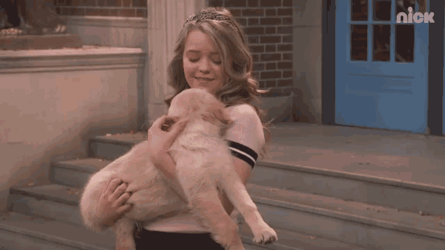 a woman is holding a puppy in front of a door that says nick on it