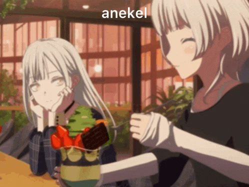 a couple of anime girls sitting at a table with the word anekel on the bottom left