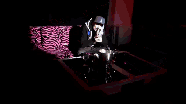 a man wearing a zebra print hoodie is laying on the floor