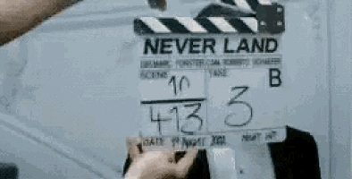 a person is holding a clapper board that says `` never land '' on it .
