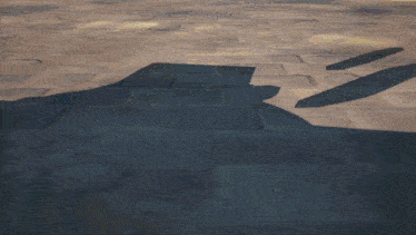 a person 's shadow is cast on a brick floor