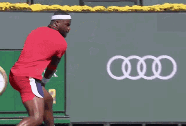 a tennis player is doing a handstand while holding a tennis racket .